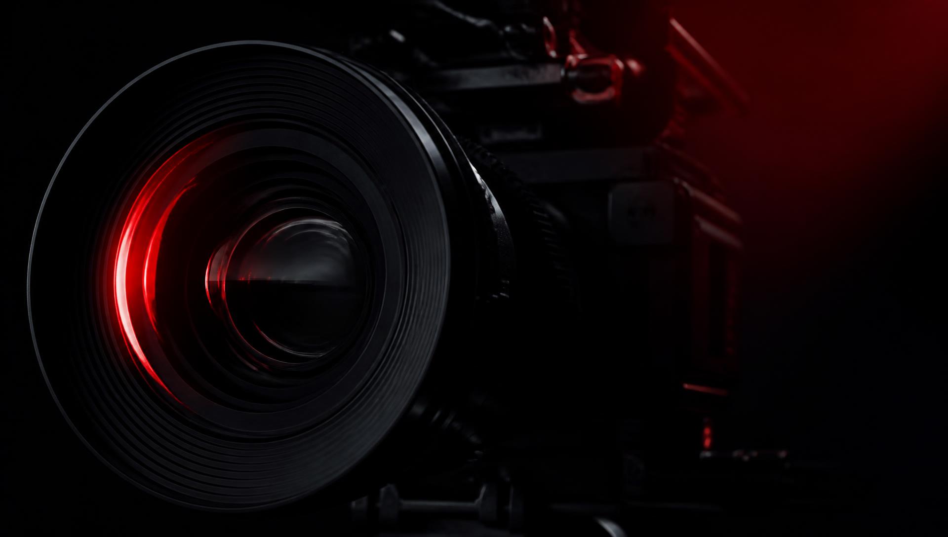 Obiettivo di una cinepresa illuminato di rosso